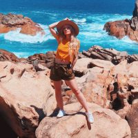 beautiful-blonde-traveler-girl-wearing-hat-and-yellow-t-shirt-at-the-rocky-beach-in-australia.jpg